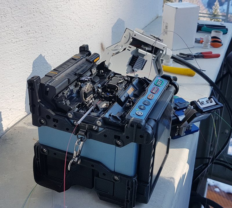Fujikura 70S core-alignment fusion splicer with the wind protector open, set up for a field splice